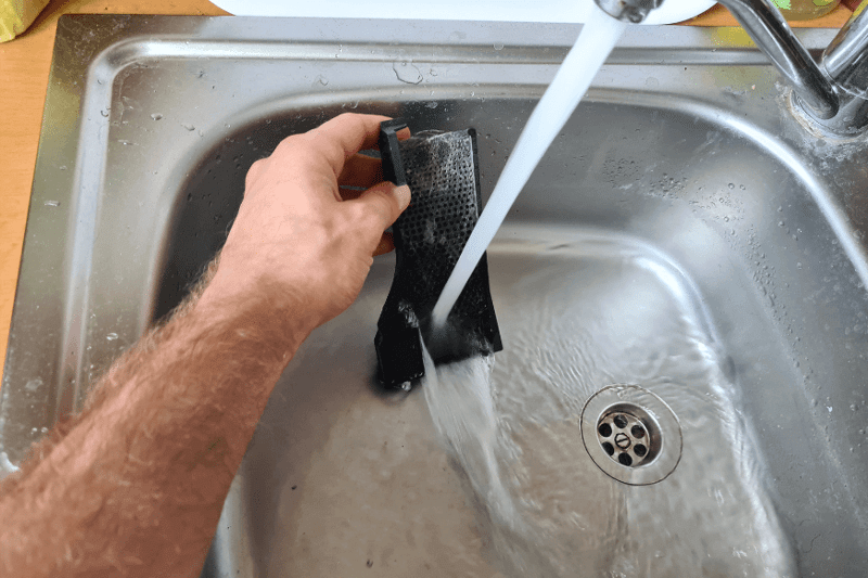 The filter from the Roborock S7 Pro Ultra Station is washed under running water.